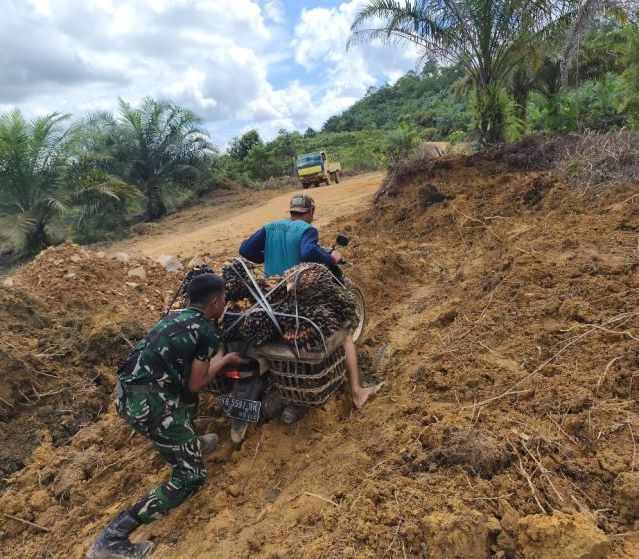 Personel Satgas TMMD Ke-128 Kodim 1204/Sanggau Bantu Warga Melintasi Jalan Rusak