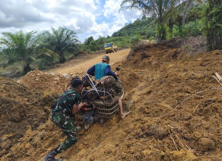 Photo of Personel Satgas TMMD Ke-128 Kodim 1204/Sanggau Bantu Warga Melintasi Jalan Rusak