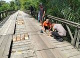 Photo of Gotong Royong Warga dan Polisi Perbaiki Jembatan Laur