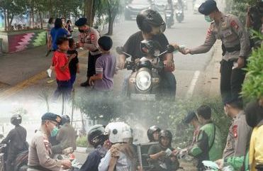Peduli Kesehatan Warga, Brimob Kalbar Bagikan Masker di Tengah Kabut Asap Karhutla
